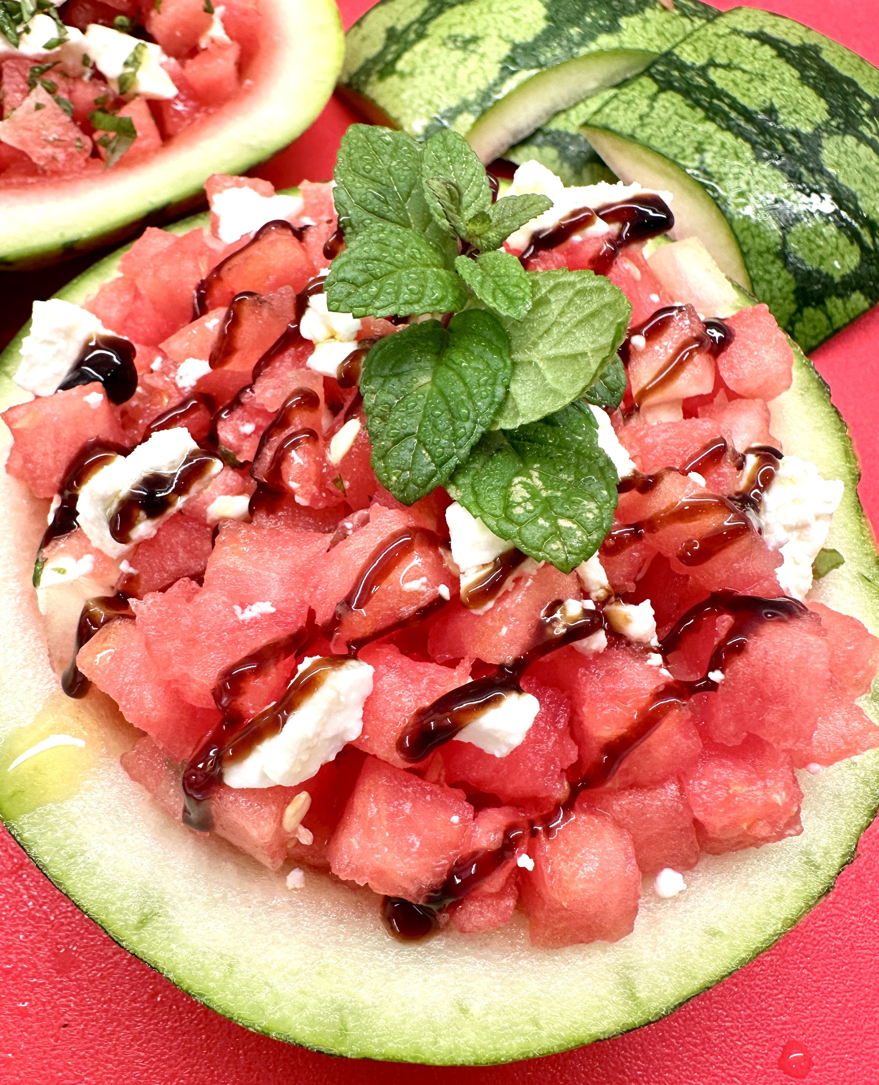 Watermelon salad with feta cheese and mint herb served inside watermelon husks